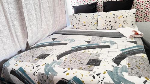 ein Bett mit einer Bettdecke und Kissen darauf in der Unterkunft S-star luxury Lounge in Roodepoort