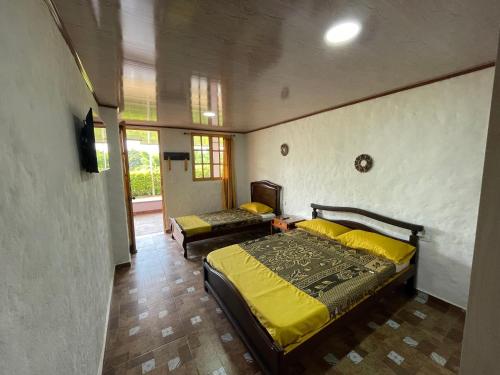 1 dormitorio con 1 cama con edredón amarillo en Casa campestre Montenegro Quindio, en Montenegro
