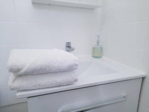 - une pile de serviettes blanches sur un comptoir dans la salle de bains dans l'établissement Duplex lumineux avec bureau séparé dans le centre, à Bordeaux