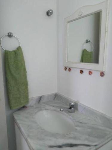 a bathroom with a sink and a mirror at Espaço Sol, Mar & Cia in Bertioga