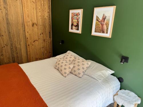 une chambre verte avec un lit avec deux oreillers dans l'établissement Marmots Clan Megève, à Megève