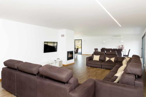 a living room with two brown couches and a couch at Casa dos Mirtilos Duke T8 in Celorico de Basto