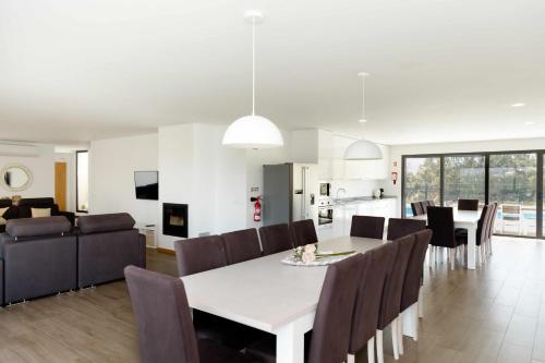 a dining room and living room with a table and chairs at Casa dos Mirtilos Duke T8 in Celorico de Basto