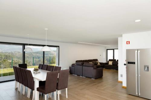 a dining room and living room with a table and chairs at Casa dos Mirtilos Duke T8 in Celorico de Basto
