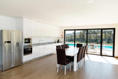 a kitchen with a table and chairs and a refrigerator at Casa dos Mirtilos Duke T8 in Celorico de Basto