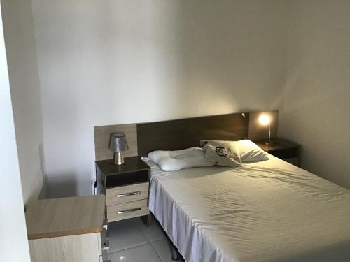 1 dormitorio con 1 cama y vestidor con lámpara en Quitieenete Arraial do Cabo, en Arraial do Cabo