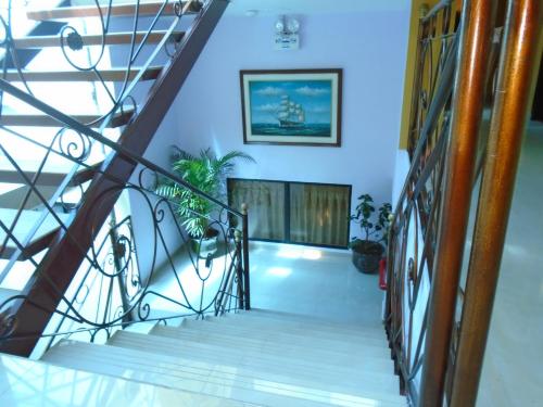 a staircase in a house with blue walls and white floors at Hotel El Ejido in Quito