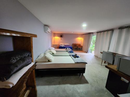um quarto com 2 camas e uma televisão em CASA DE VIDRO COM VISTA PARA O MAR em São Sebastião