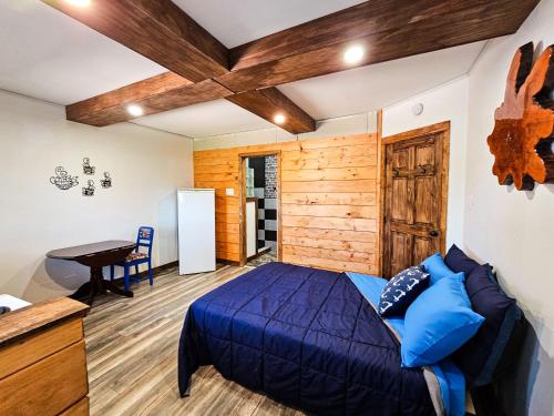 ein Schlafzimmer mit einem blauen Bett und einer Holzwand in der Unterkunft Gite touristique eaux bons vievents in Lac-Bouchette