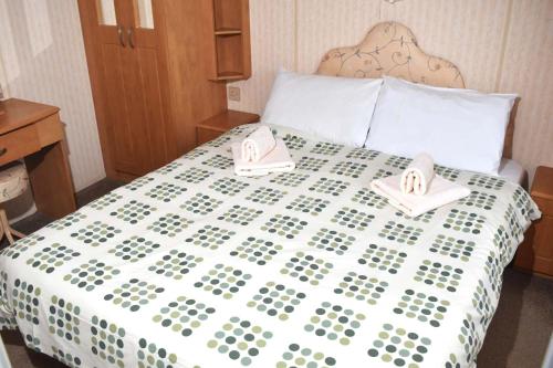 a bedroom with a bed with two towels on it at Brisbane Bronze - pet friendly SS21 in Minehead