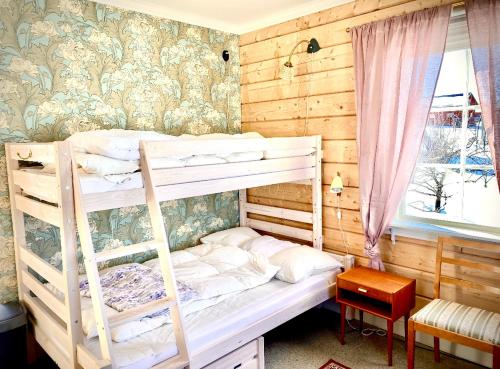 1 Schlafzimmer mit 2 Etagenbetten und einem Fenster in der Unterkunft Scenic small guesthouse on horse farm by the lake in Frösö