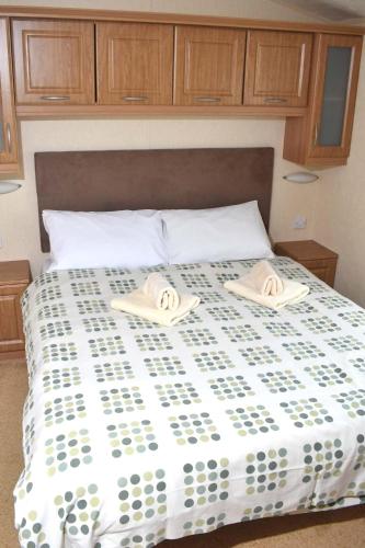 una camera da letto con un letto e due asciugamani di Caprice Gold SU18 a Minehead