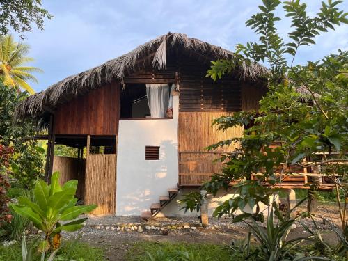 a small house with a thatched roof at Popochos Beach Eco Lodge in Nuquí
