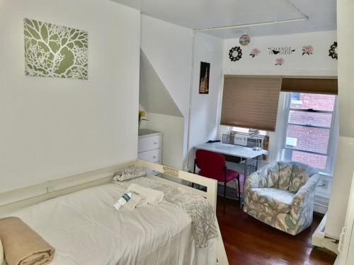 1 dormitorio con cama, silla y escritorio en West End Haven, en Hartford