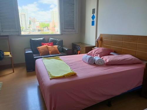 um quarto com uma cama grande e um sofá em Apartamento Centro Belo Horizonte em Belo Horizonte