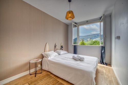 een slaapkamer met een wit bed en een raam bij Le Lyon - Bastille / Esplanade in Grenoble