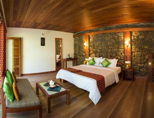 a bedroom with a bed and a stone wall at Neelakurunji Plantation Munnar in Chinnakanal