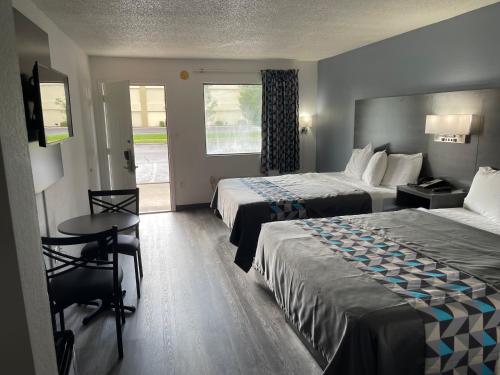 帕迪尤卡的住宿－American Inn - Paducah，酒店客房设有两张床和一张桌子。