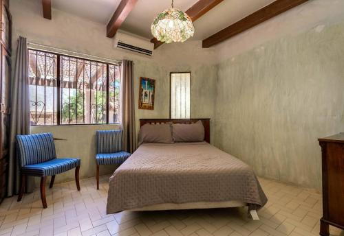- une chambre avec un lit et deux chaises bleues dans l'établissement Casa Habana as seen in the movie Inferno, à San Felipe