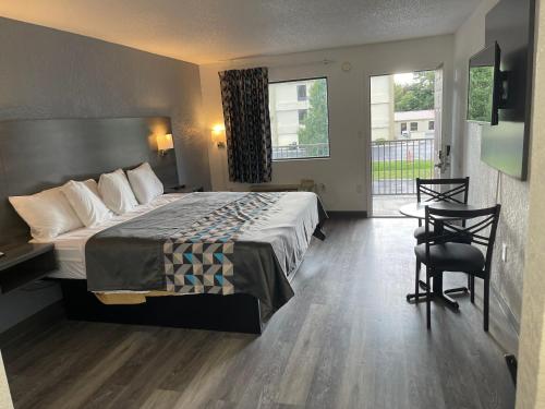 a hotel room with a bed and a desk and chair at American Inn - Paducah in Paducah