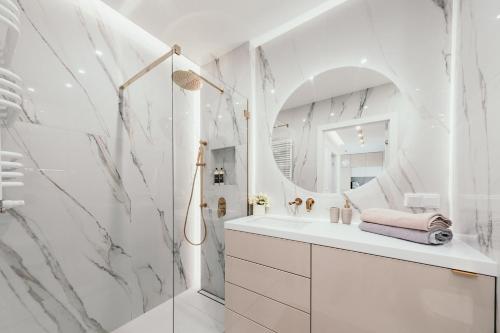 a white bathroom with a sink and a mirror at Sea & Stadium plaża Brzeżno in Gdańsk