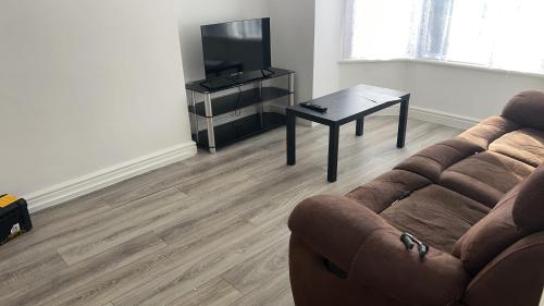 a living room with a couch and a table and a television at The Coral Guest House 1 Mile from Winchester Market in Winchester