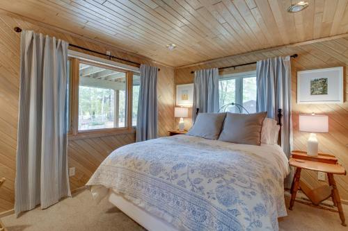 Waterfront Potato Lake Getaway with Deck! في Arago: غرفة نوم بسرير في غرفة بجدران خشبية