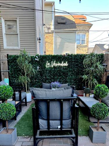 a black chair sitting in a yard next to a hedge at Chicago - Pilsen Studio apartment - Unit B in Chicago