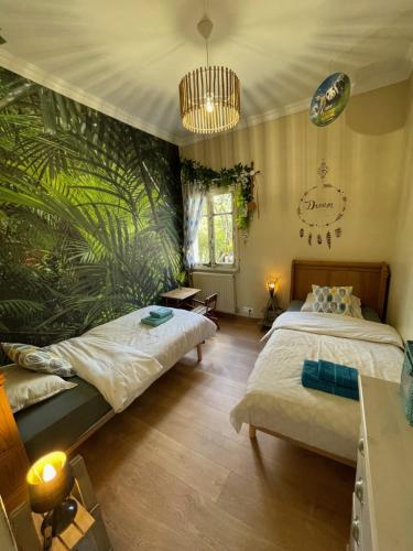 2 camas en una habitación con papel pintado tropical en Domaine entier Le Clos des Trois Provinces 20 personnes Zoo Beauval, en Noyers-sur-Cher