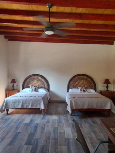 a bedroom with two beds and a ceiling fan at Rancho Espinoza La Casita in San Ignacio
