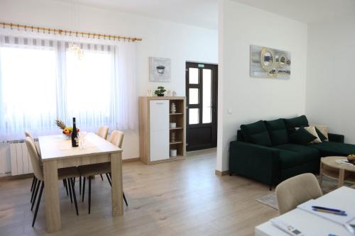 a living room with a green couch and a table at Apartman Tip Top in Gospić