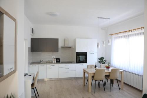 a white kitchen with a table and chairs at Apartman Tip Top in Gospić