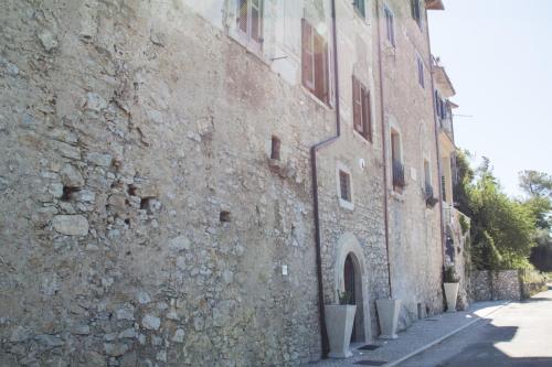 a large stone building next to a street at Palazzo Tronconi agriturismo in Arce