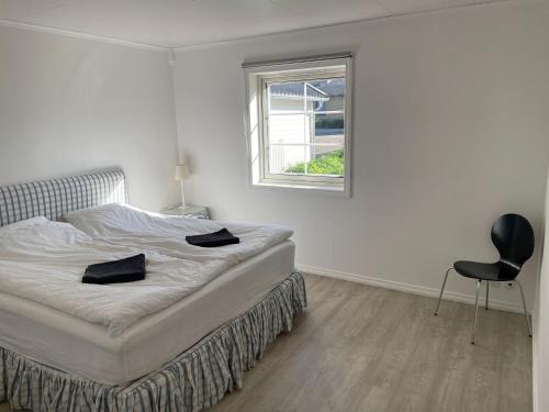 - une chambre avec un lit, une chaise et une fenêtre dans l'établissement Stort familie hus (156 m2) tæt på natur og storby, à Herlev