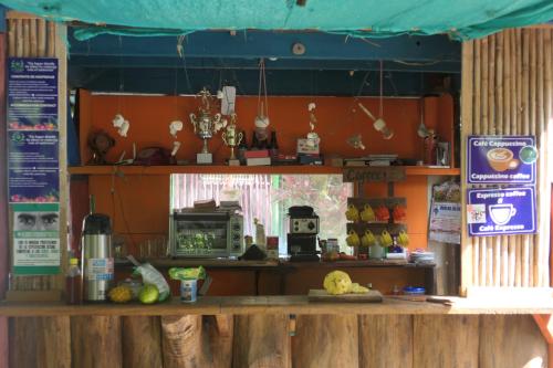a coffee shop with a counter with a microwave at Eco-Cafe El Mirador in Guachaca