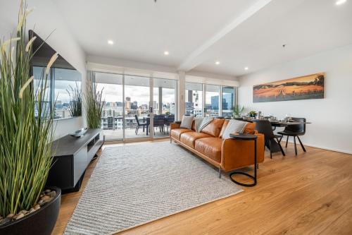 a living room with a couch and a table at Ignite at Park Terrace - Elevated City Living in Adelaide