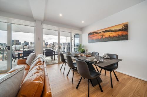 a dining room with a couch and a table with chairs at Ignite at Park Terrace - Elevated City Living in Adelaide