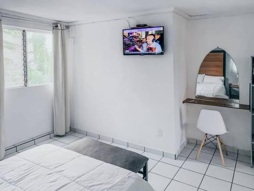 um quarto com uma cama e uma televisão na parede em La Casa del Expositor em Guadalajara