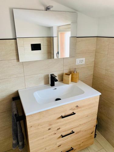 a bathroom with a white sink and a mirror at Casa Il Maestrale in Quartu SantʼElena
