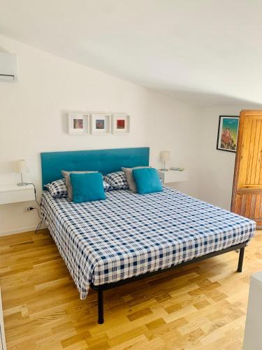 a bedroom with a bed with a blue headboard at Casa Il Maestrale in Quartu SantʼElena