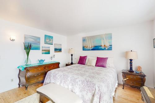 a bedroom with a bed with purple pillows and a chair at Hazel Eyes in Nipomo