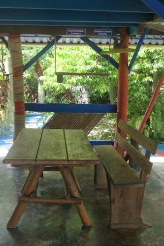 a picnic table and a bench under a gazebo at Eco-Cafe El Mirador in Guachaca