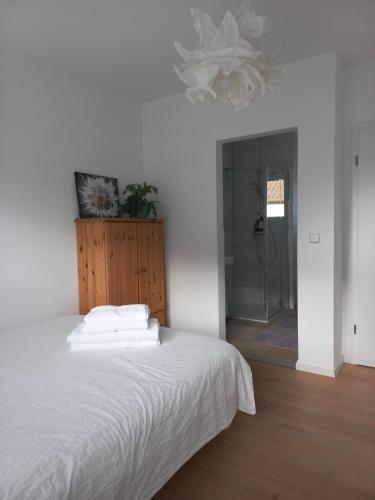 a bedroom with a white bed and a shower at Privates Zimmer mit Bad in Efringen-Kirchen