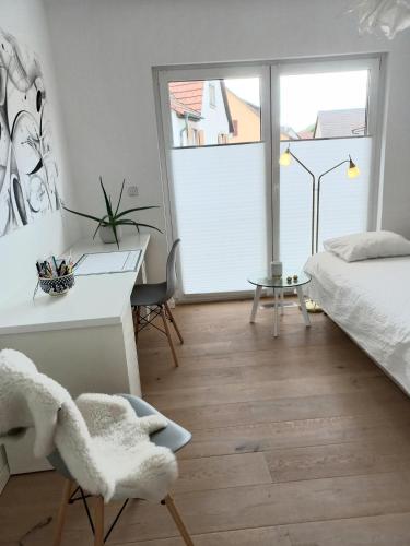 um quarto com uma cama, uma secretária e uma janela em Privates Zimmer mit Bad em Efringen-Kirchen