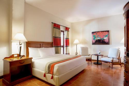 une chambre d'hôtel avec un lit et une chaise dans l'établissement Hotel Boutique Las Palomas de Santiago Pueblo Mágico, à Santiago