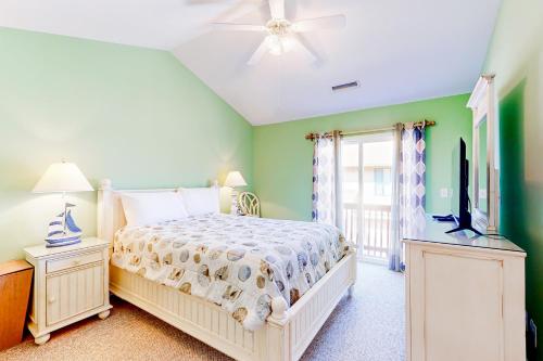 um quarto com uma cama e uma televisão de ecrã plano em The Singing Gull em Myrtle Beach