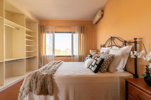 sypialnia z łóżkiem z poduszkami i oknem w obiekcie Bellavista Aeropuerto w mieście Aguatona