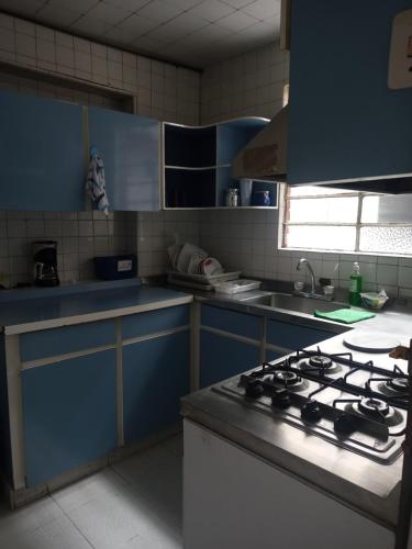 a kitchen with blue cabinets and a stove top oven at House Beautiful Horizon P1 in Bogotá