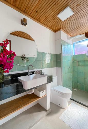 a bathroom with a sink and a toilet at Vila Real Apartamentos in Itacaré