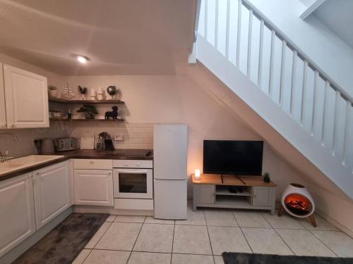 a kitchen with a white refrigerator and a staircase at Cosy Moat House Cottage #6 in Pembroke